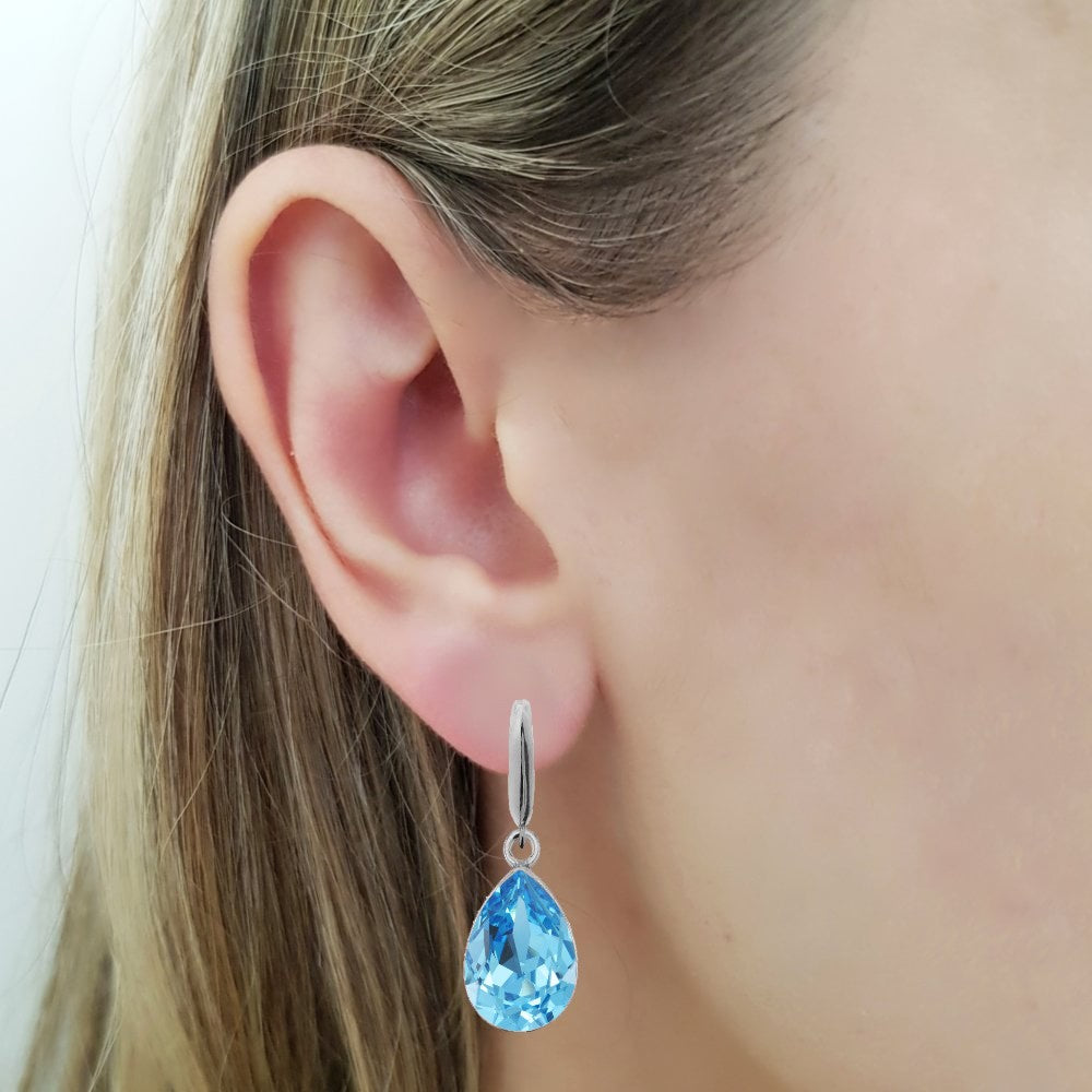 Woman wearing a Dangling Pear-Cut Drop Earrings in Sterling Silver with Aquamarine Blue Teardrop Austrian Crystals