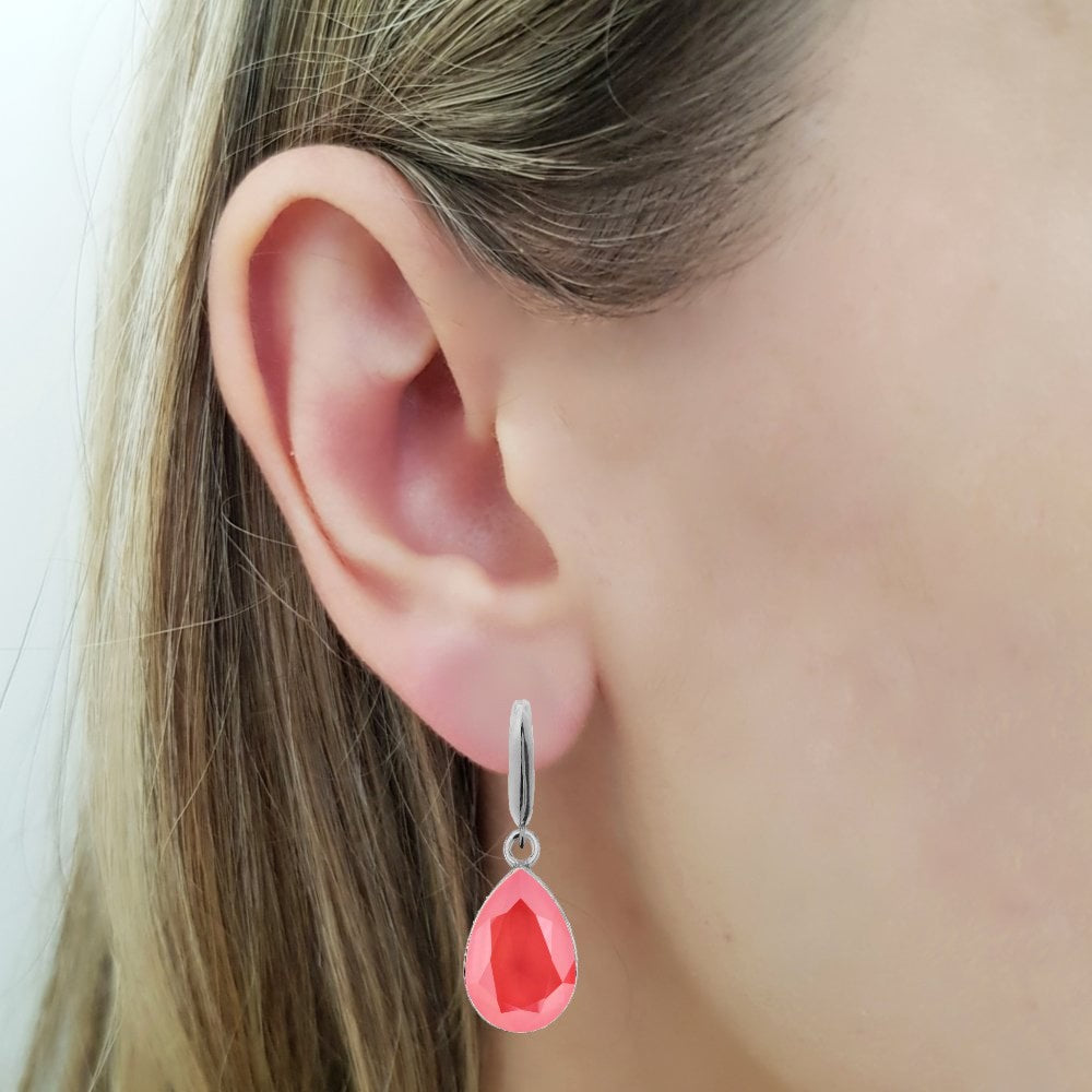 Woman wearing a Dangling Pear-Cut Drop Earrings in Sterling Silver with Light Coral Orange Teardrop Austrian Crystals