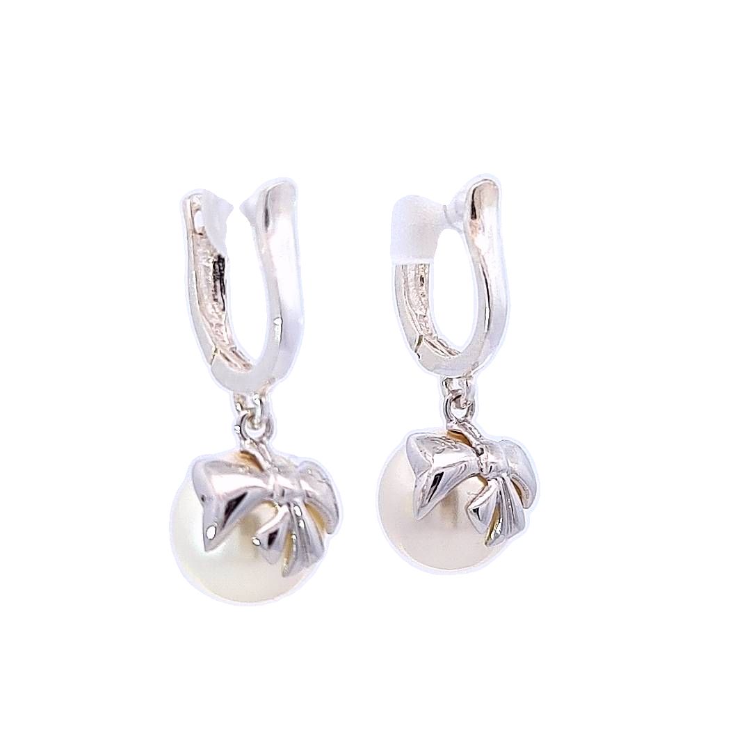 Side View of the White Pearl Drop Huggie Earrings in Sterling Silver