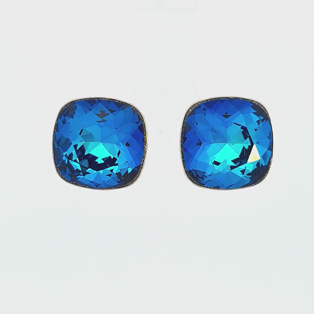 Video showcasing Silver Cushion Stud Earrings with Bermuda Blue square Austrian crystal, reminiscent of ocean depths, evoking serenity and introspection.