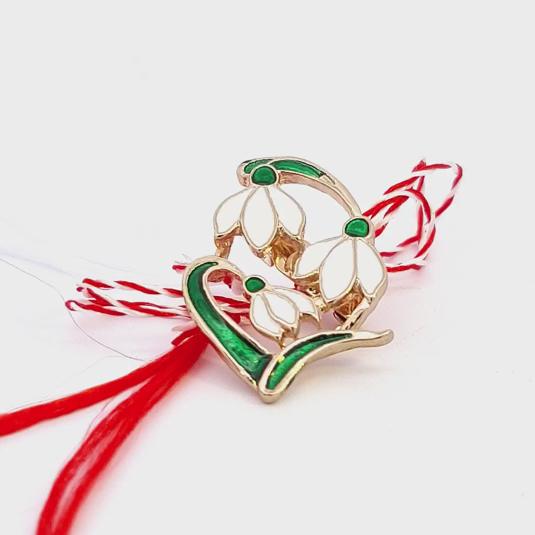 Intricately crafted snowdrop Martisor brooch symbolising hope, by Magpie Gems, complete with red and white bow.