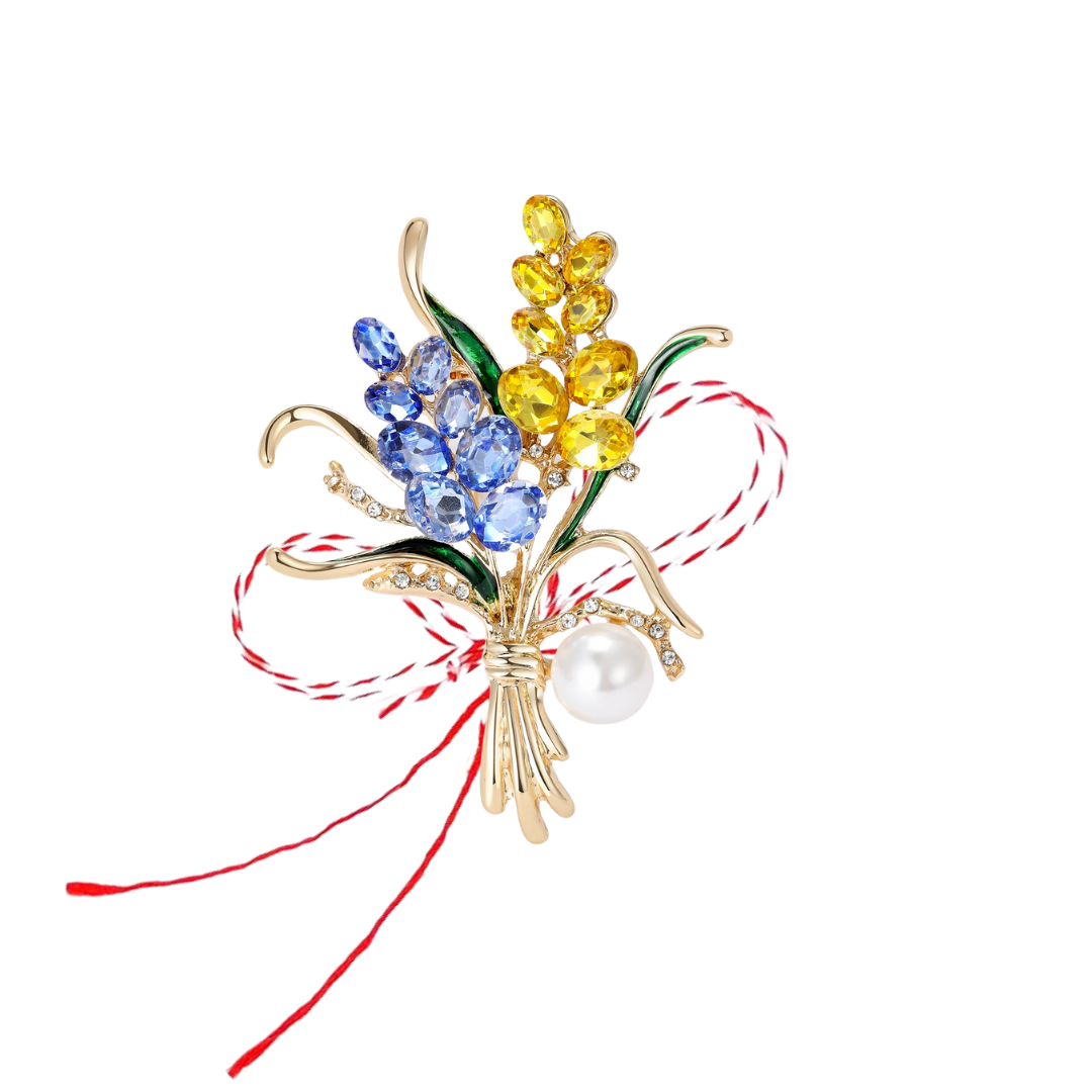 Yellow and Blue Lavender Martisor Brooch featuring sparkling gemstones, green enamelled leaves, a gold-toned bouquet design, and a lustrous pearl accent, paired with the traditional red and white Martisor bow to symbolise spring and renewal.