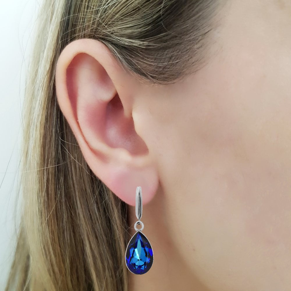 Woman wearing a Dangling Pear-Cut Drop Earrings in Sterling Silver with Bermuda Blue Teardrop Austrian Crystals