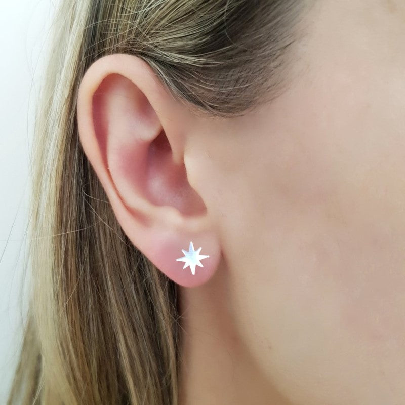 Woman wearing Winter Star Sterling Silver Stud Earrings showcasing elegant and minimalist star design for Christmas, made in Ireland by Magpie Gems.