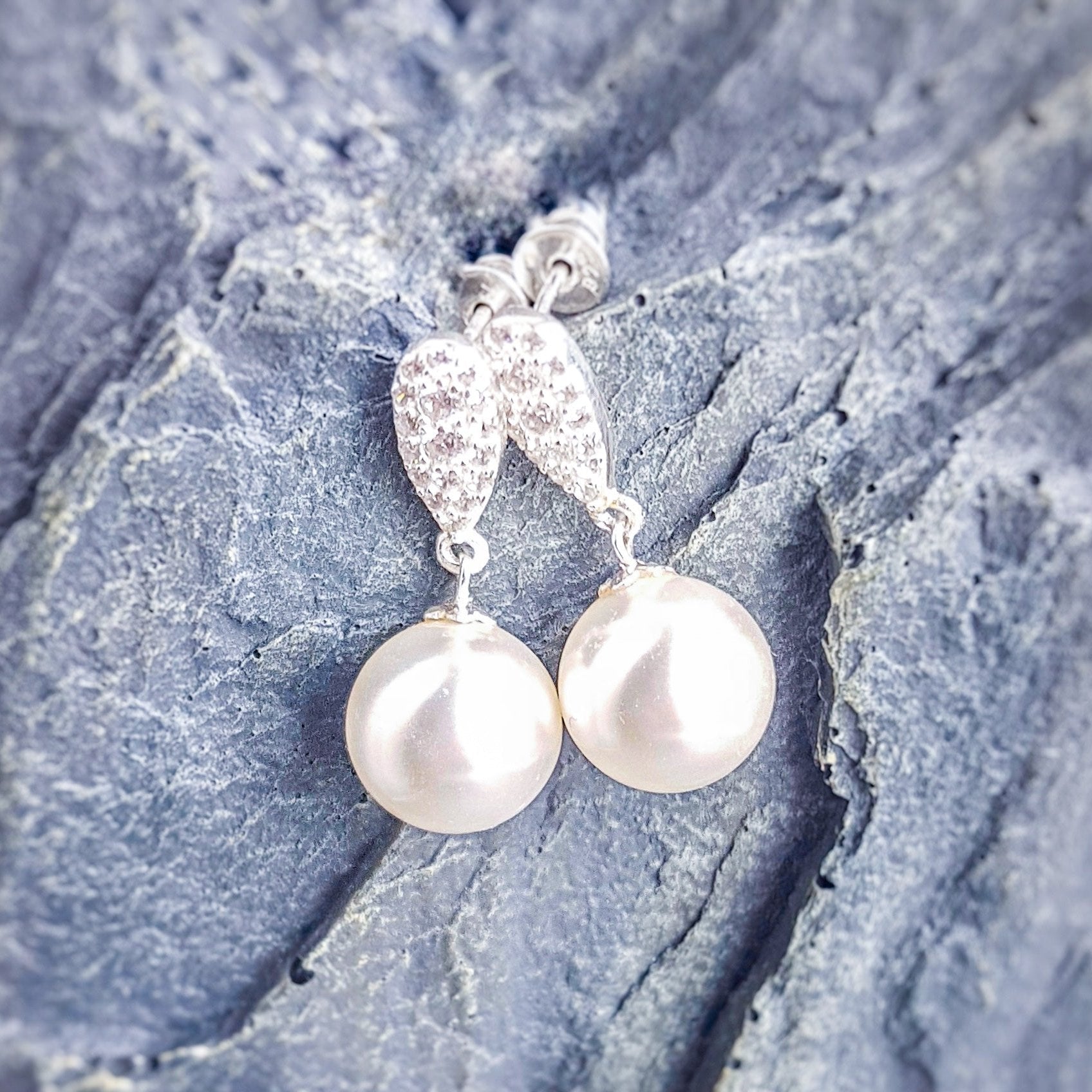 Front view of Elegant Pearl Drop Earrings in Sterling Silver with 12mm white pearls and Austrian crystal teardrop detail